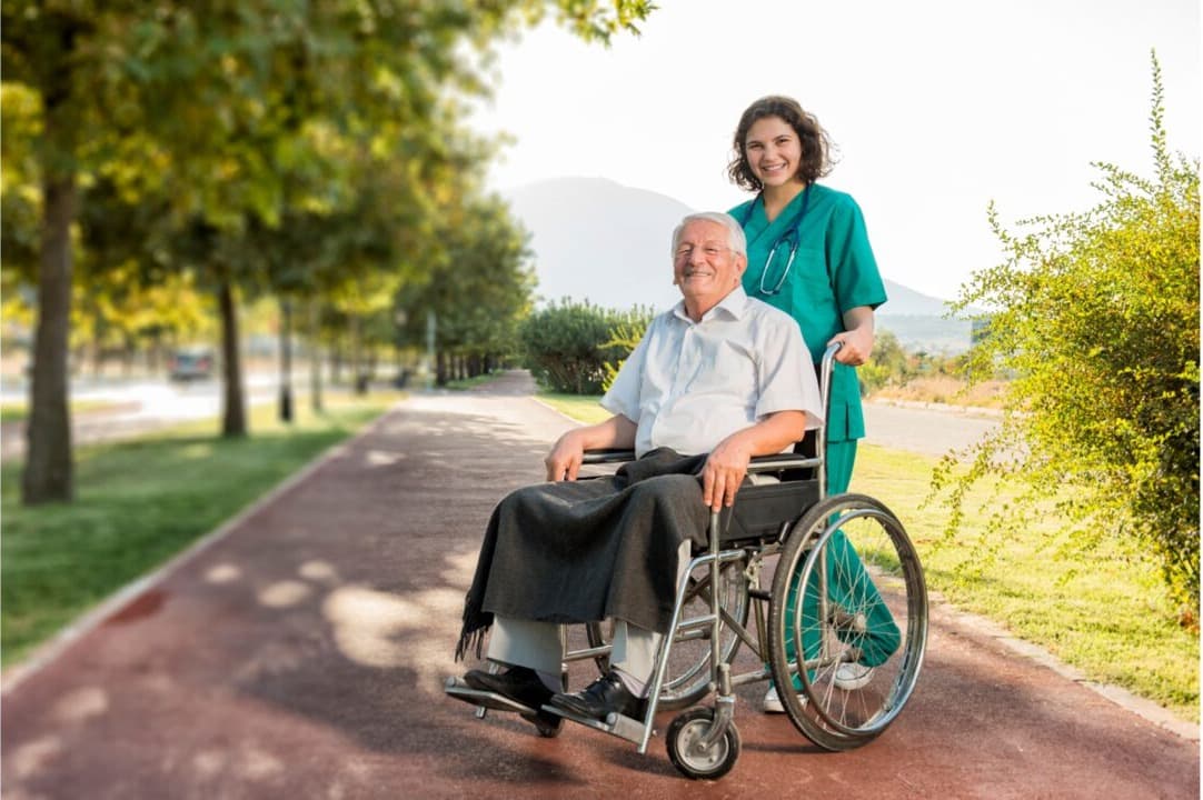 A carer supporting an older man as he walks and regains his confidence