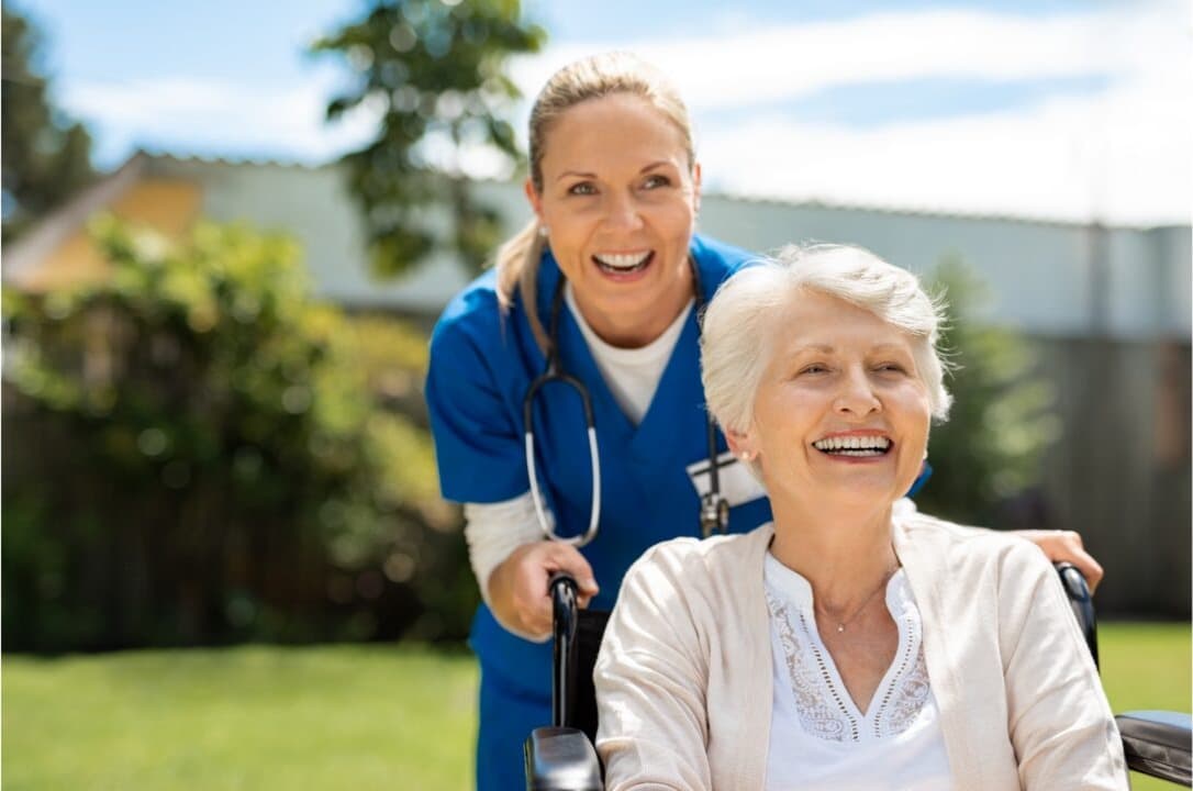A care worker walking calmly alongside an older woman outdoors